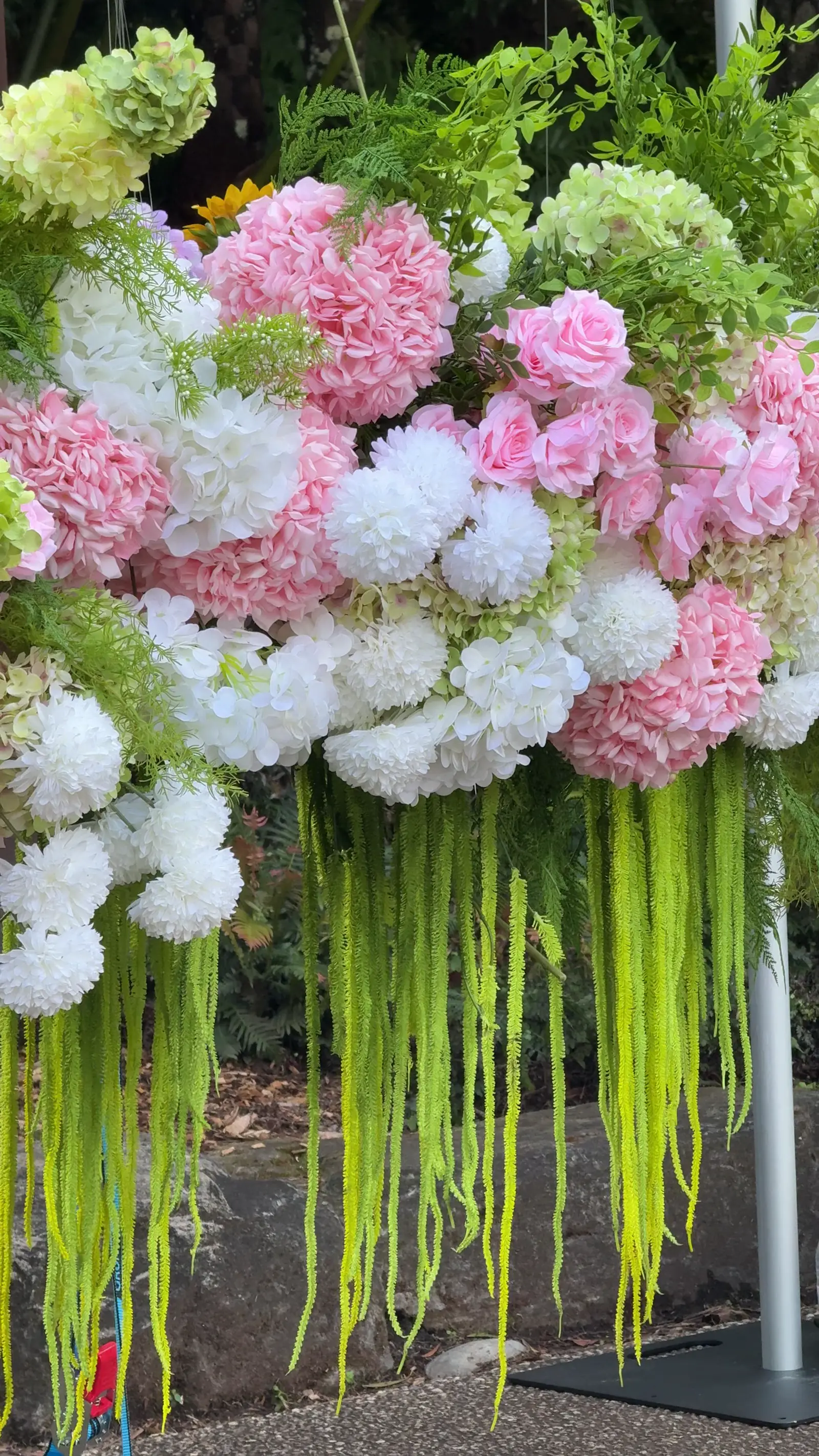 A tall pink and white floral arrangement for a reception or lobby.