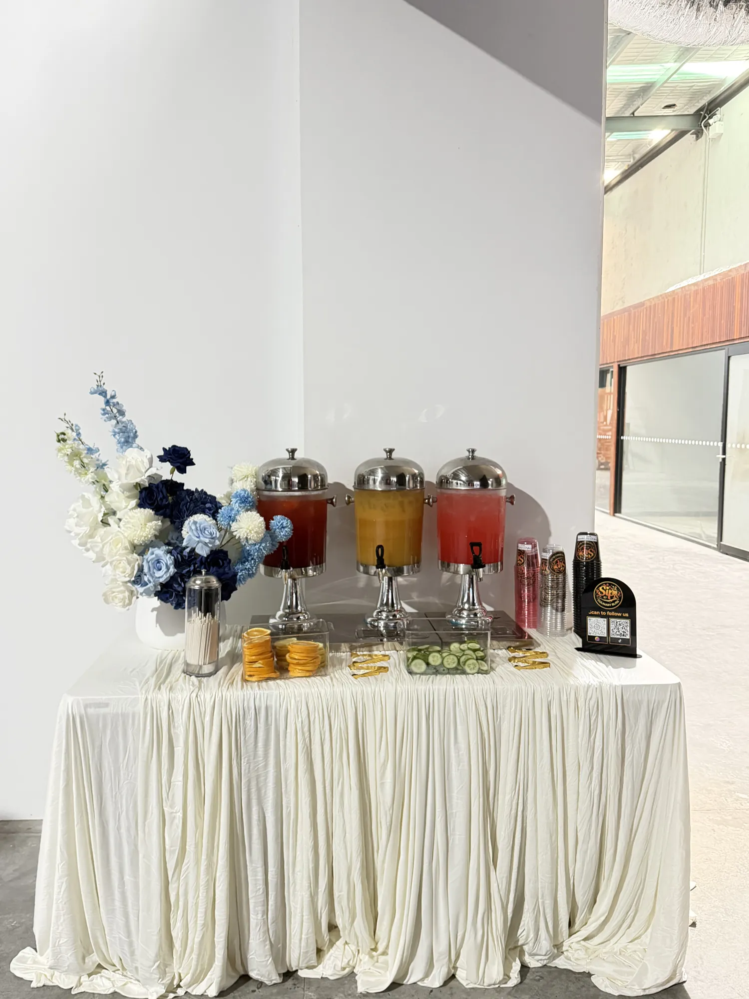 A white backdrop of red and white roses, with a two-tier white cake and a gold 60 on a glass stand.