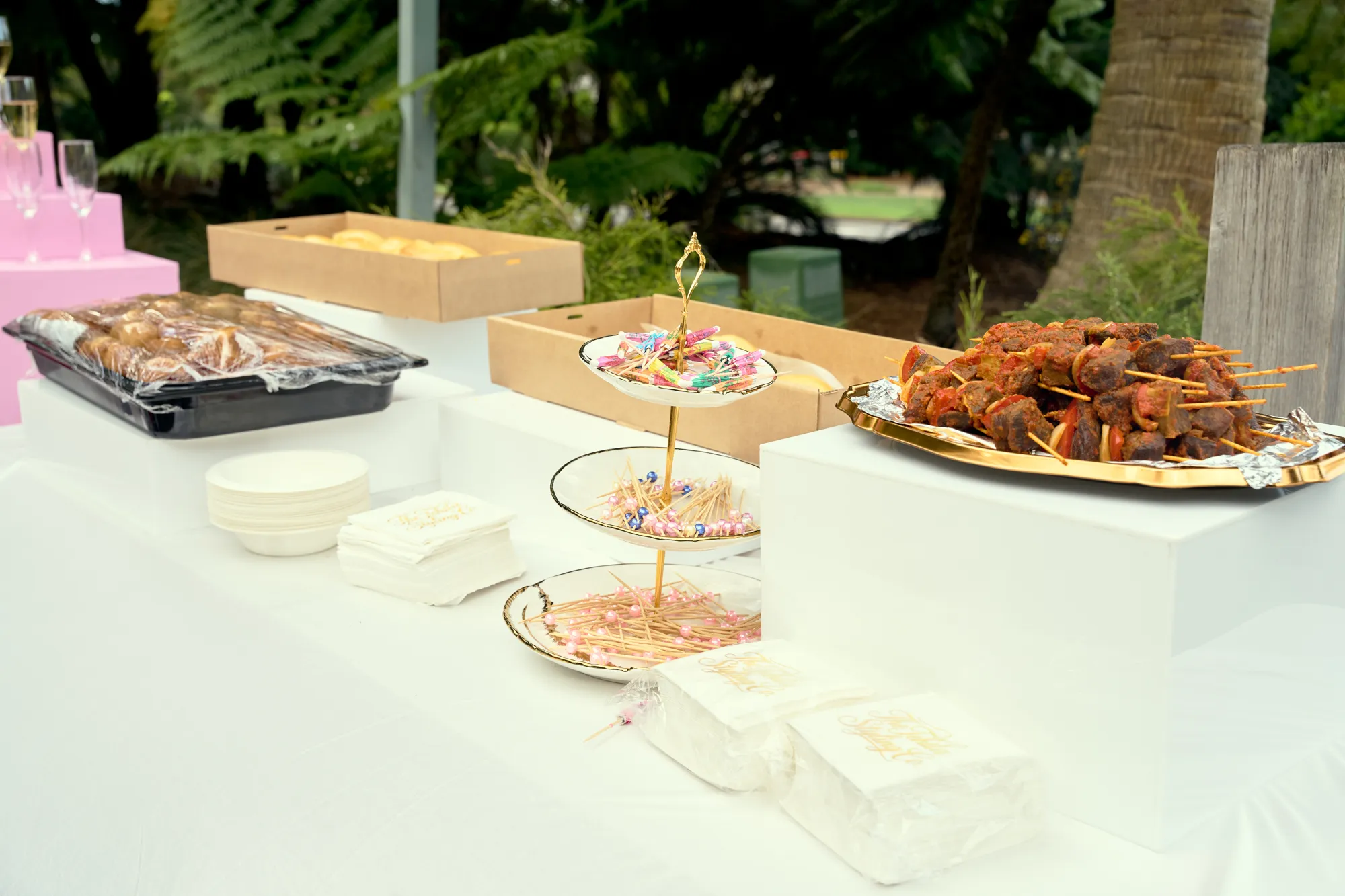 A grazing table of cheeses, cured meat, fruit, crackers, and dips, with a round white sign reading Grazing.